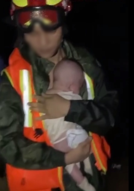  
Một em bé khác được lực lượng cứu hỏa giải cứu ngay trong đêm. (Ảnh cắt từ clip)