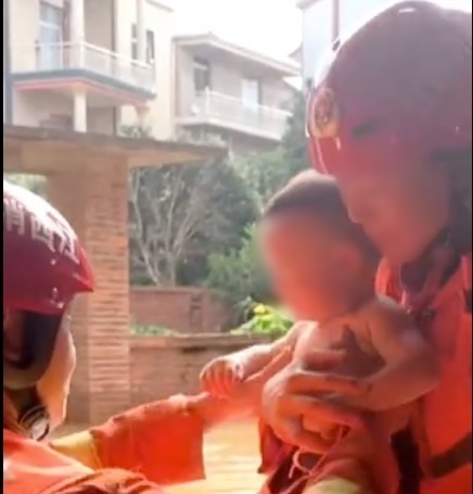  
Em bé được trao cho các lính cứu hỏa. (Ảnh cắt từ clip)