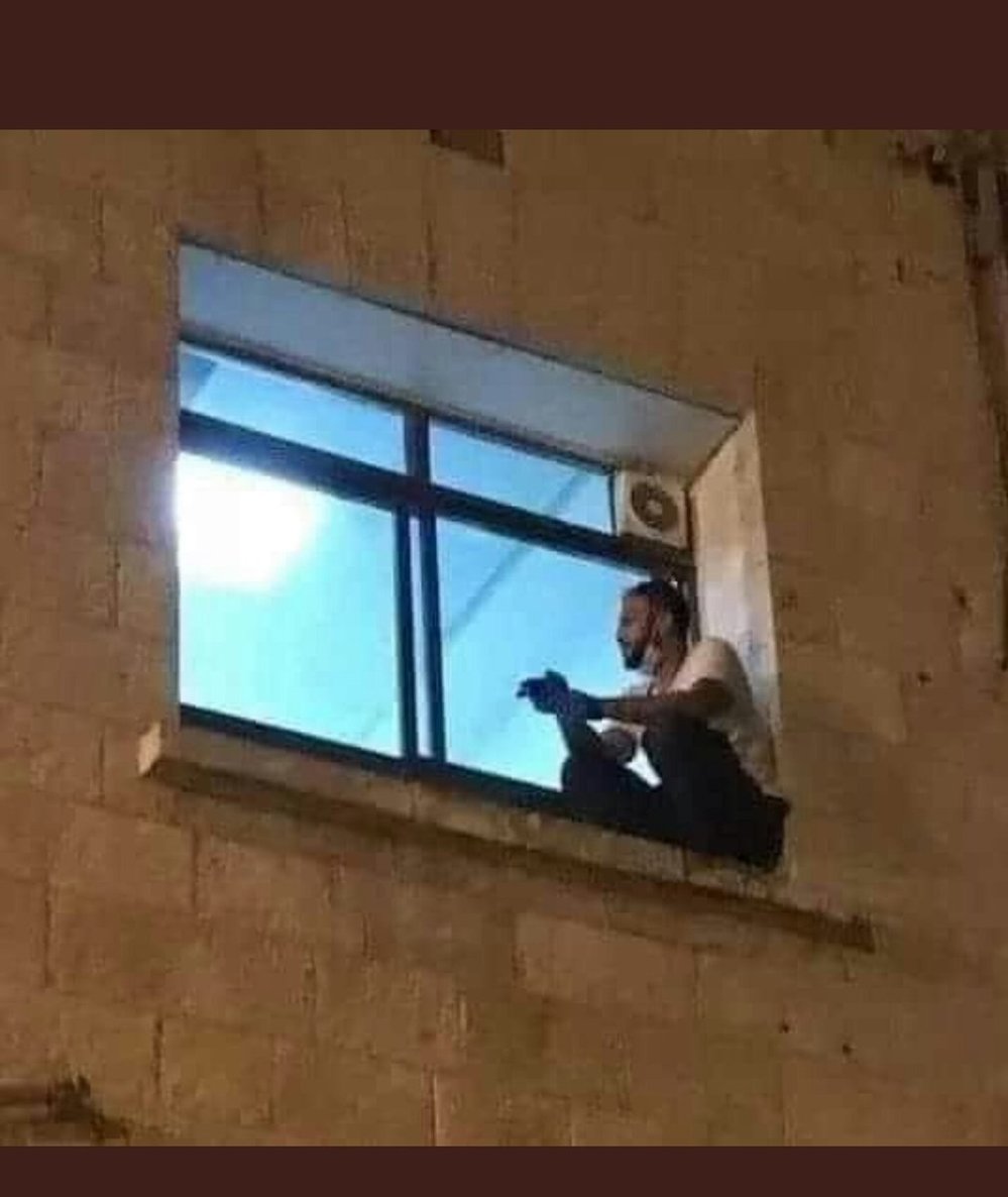  
Jihad ngồi trên bệ cửa sổ của bệnh viện để nhìn mẹ. (Ảnh: Twitter)