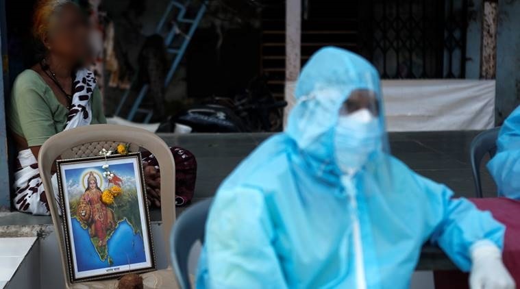 
Hình ảnh một nhân viên y tế ở Ấn Độ mang theo bức ảnh 1 vị thần trong lúc đang làm việc (Ảnh: Reuters)