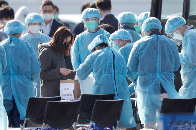  
Nhân viên y tế mặc đồ bảo hộ lao động ở nơi công cộng. (Ảnh: AFP)