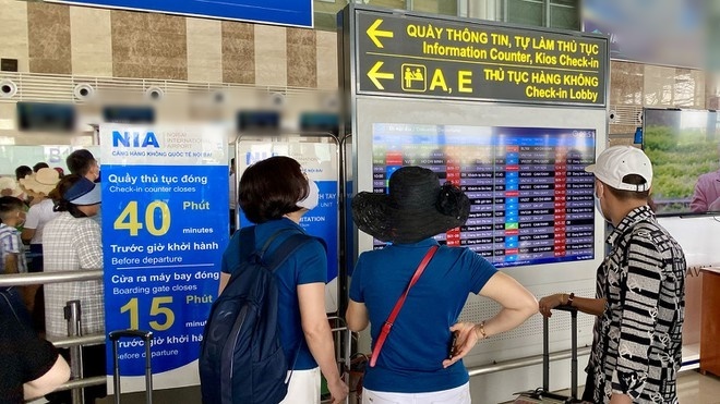  
Hành khách đang theo dõi màn hình điện tử hiển thị thông tin chuyến bay ở sân bay Nội Bài. (Ảnh:  Văn phòng Cảng hàng không Nội Bài)