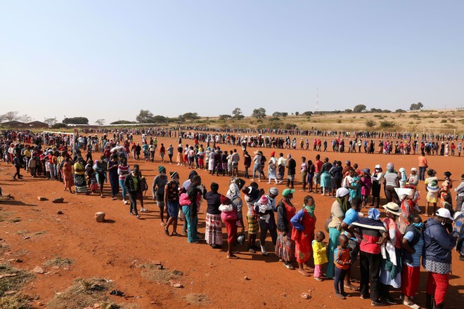  
Mọi người xếp hàng đứng chờ để được nhận lương thực từ thiện ở Nam Phi. (Ảnh: Reuters)