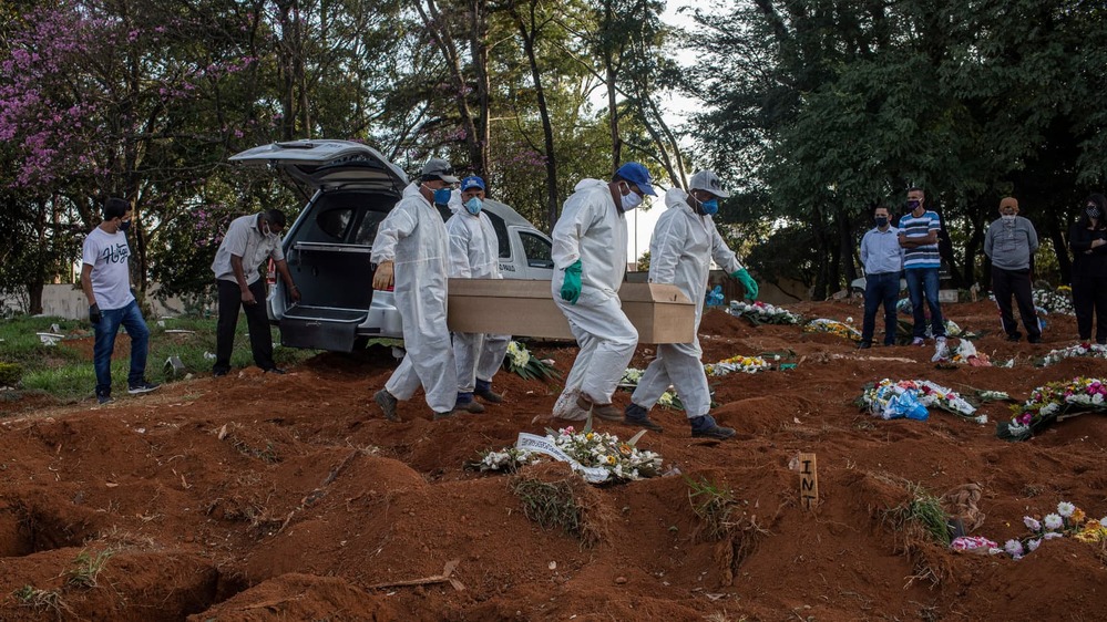  
Các nhân viên ở Brazil đang đưa người tử vong vì Covid-19 đến khu vực chôn cất. (Ảnh: The New York Times)