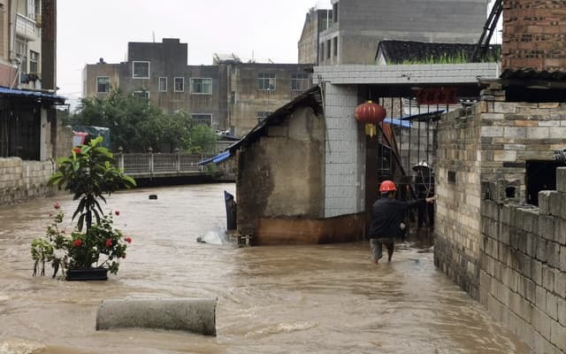  
Một khu vực nhà dân ở Trung Quốc bị ngập nước gần tới đầu gối. (Ảnh: AP)