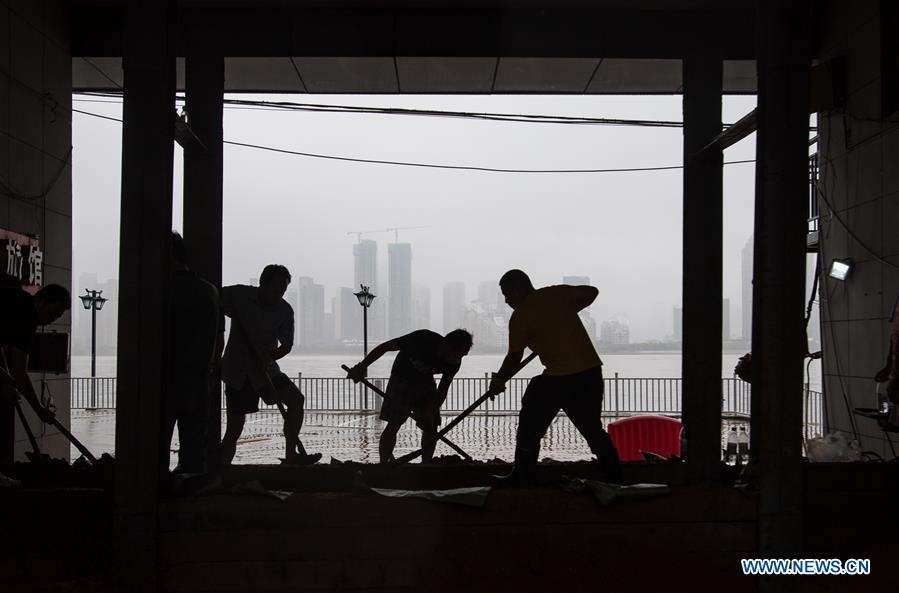 Mọi người đang gia cố lại đê trên sông ở Vũ Hán. (Ảnh: China Daily)