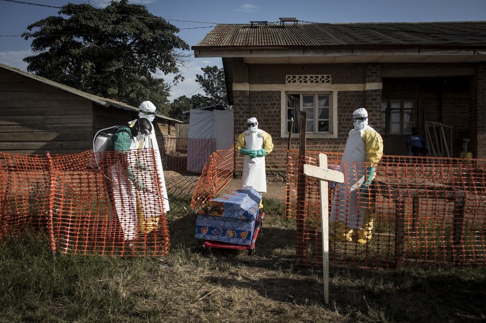  
Nhân viên y tế phun thuốc khử trùng xung quanh một quan tài của bệnh nhân nhiễm Ebola tại Beni, CHDC Congo. (Ảnh: AFP) 
