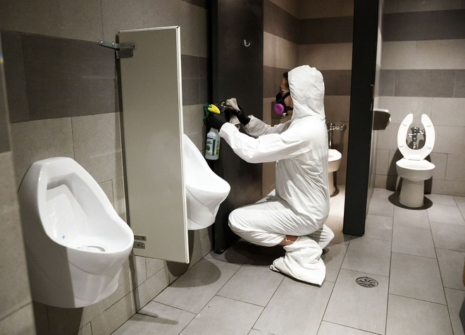 
Nhân viên y tế làm việc trong 1 nhà vệ sinh (Ảnh: Bloomberg)