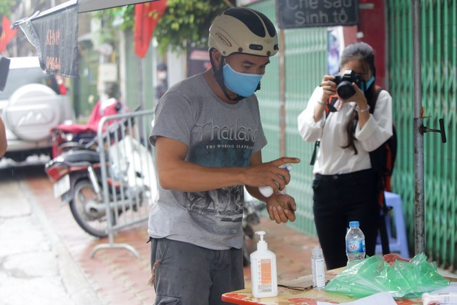  
Một người đứng rửa tay diệt khuẩn tại chốt cách ly đầu ngõ (Ảnh: Tiền Phong)