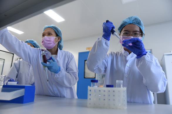  
Các chuyên gia ở ​Công ty cổ phần công nghệ sinh học dược Nanogen đang thực hiện 1 công đoạn trong quá trình nghiên cứu sản xuất vắc xin Covid-19. (Ảnh: Tuổi Trẻ)