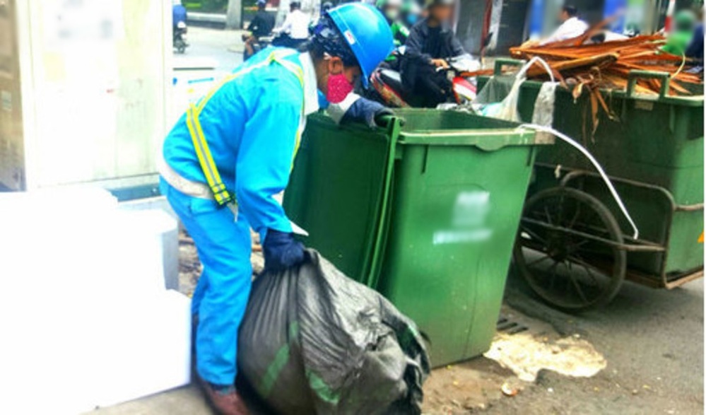  
Công nhân môi trường đang tiến hành thu gom rác. (Ảnh: Hà Nội Mới)