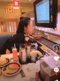  
Cô gái trẻ bị lên án vì hành động quay clip liếm đĩa sushi trên băng chuyền. (Ảnh cắt từ clip)