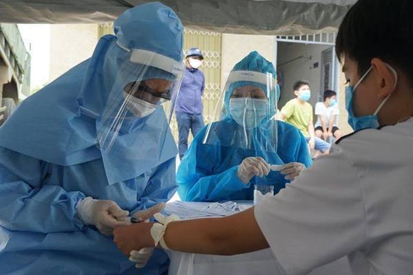  
Nhân viên y tế lấy mẫu xét nghiệm Covid-19 cho mọi người (Ảnh: Vietnamnet)