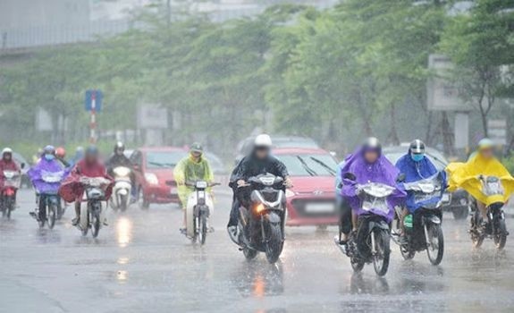 
Mọi người di chuyển ngoài đường trong cơn mưa lớn. (Ảnh: Lao Động)
