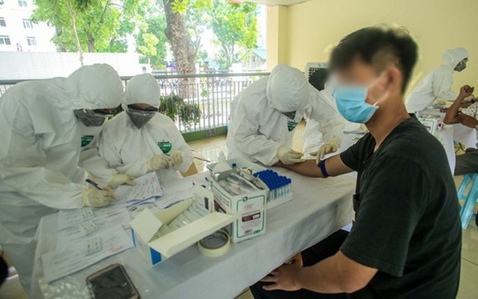 
Nhân viên y tế lấy mẫu xét nghiệm Covid-19 cho người trở về từ Đà Nẵng (Ảnh: Người Lao động)