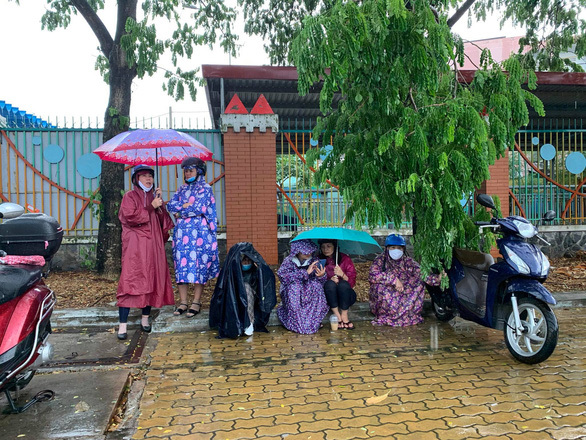  
Tại TP. Hồ Chí Minh mưa to từ khá sớm, nhiều bậc phụ huynh đội mưa đợi con em thi. (Ảnh: Tuổi trẻ)