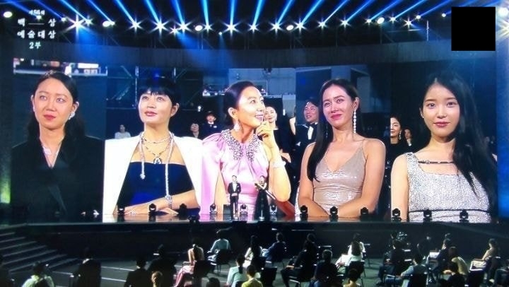  
Tại một sự kiện, khi camera lia tới, chỉ có mình IU là tự tin nhìn trực diện, trong khi 4 chị đại không biết gì (Ảnh: Naver)