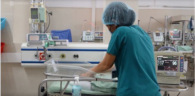  
Nhân viên y tế tiến hành chăm sóc sức khỏe cho bé sơ sinh. (Ảnh: VnExpress)