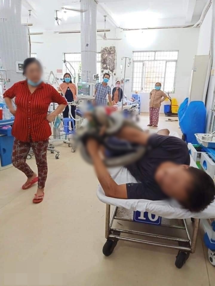 Ông P.V.T. (38 tuổi, tỉnh Tây Ninh) cầm chặt con rắn hổ mang chúa khi đến bệnh viện để cấp cứu. (Ảnh: FB Không Sợ Chó)