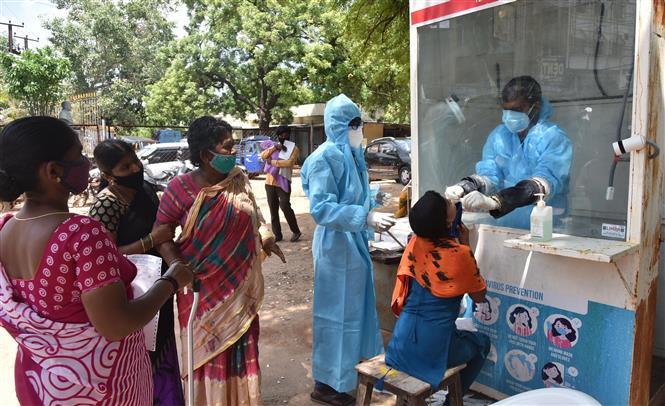  
Nhân viên y tế đang lấy mẫu xét nghiệm cho mọi người ở Ấn Độ. (Ảnh: AFP)
