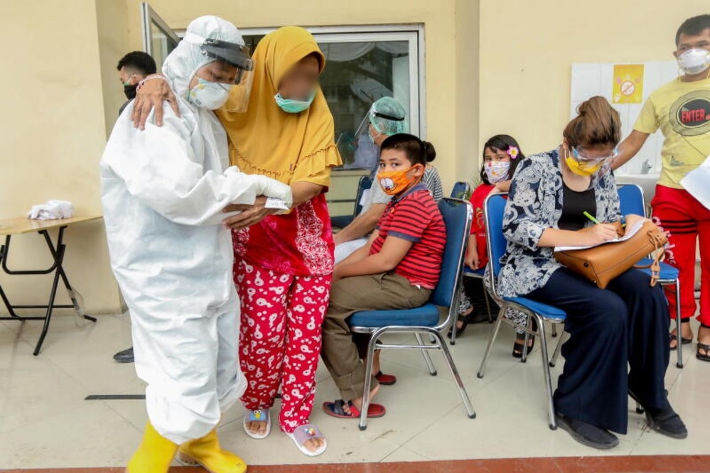  
Nhân viên y tế hỗ trợ một phụ nữ đến xét nghiệm Covid-19 ở Philippines ngày 27/8. (Ảnh: The Straits Times)