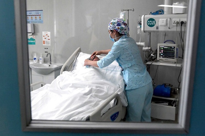 
Một nhân viên y tế đang chăm sóc cho một bệnh nhân ở Trung Quốc. (Ảnh: Tân Hoa Xã)