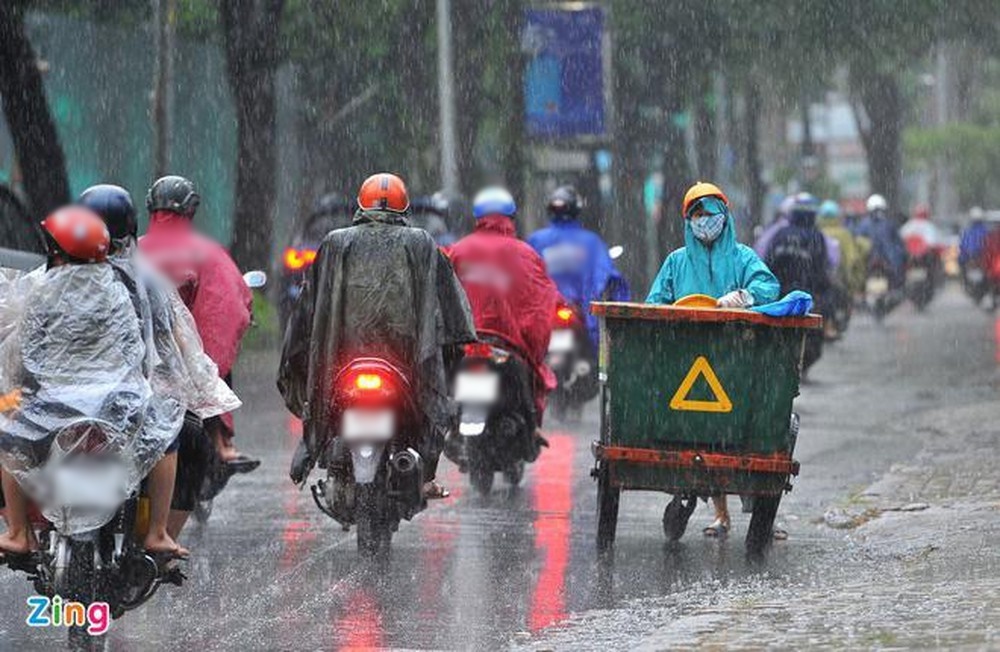  
Mọi người mặc áo mưa di chuyển ngoài đường trong cơn mưa lớn. (Ảnh: Zing)