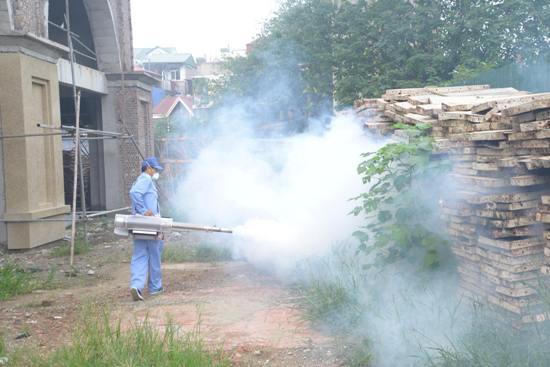  
Một người đang phun hóa chất diệt côn trùng xung quanh các hộ gia đình. (Ảnh: Báo Tin Tức)