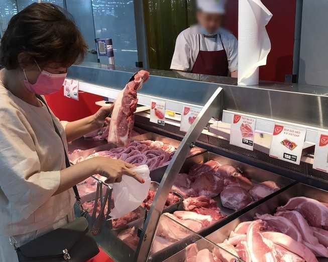  
Người tiêu dùng chọn mua thịt lợn tại quầy hàng trong siêu thị (Ảnh: 24h)