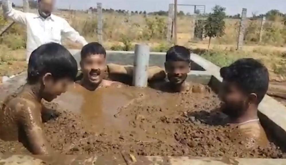  
Những người đàn ông tắm trong phân bò (Ảnh cắt từ video)