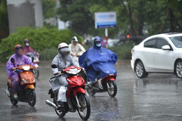  
Người đi đường mặc áo mưa di chuyển trong cơn mưa lớn. (Ảnh: VietNamNet)