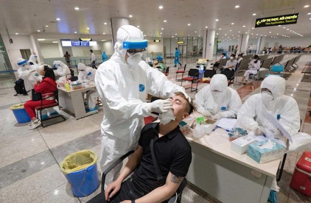 
Nhân viên y tế lấy mẫu xét nghiệm Covid-19 cho hành khách tại sân bay (Ảnh: Net News)
