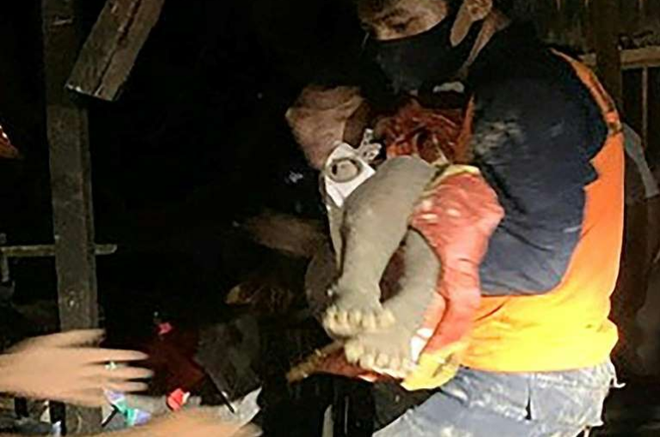  
Nhân viên cứu hộ cứu một đứa trẻ ra khỏi đống đổ nát của căn nhà. (Ảnh: AFP)