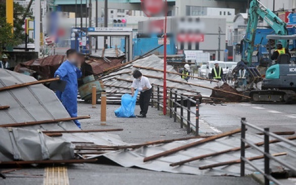  
Một nhân viên dọn dẹp di dời các mái nhà bị gió mạnh từ bão Haishen thổi bay xuống một con đường tại Fukuoka ngày 7/9. (Ảnh: AFP)