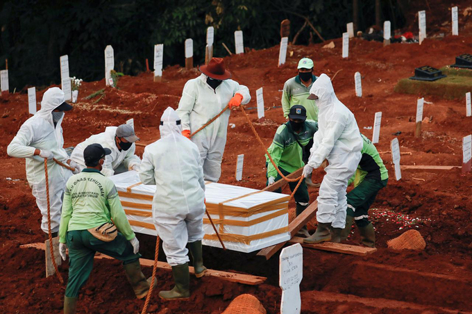  
Các nhân viên nghĩa trang chôn cất một bệnh nhân Covid-19 ở thủ đô Jakarta, Indonesia, hôm 22/4. (Ảnh: Reuters)