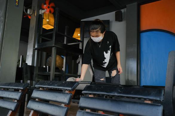  
Nhân viên một quán cà phê trên đường Đống Đa, Đà Nẵng lau dọn bàn ghế chuẩn bị phục vụ trở lại. (Ảnh: Tuổi Trẻ)