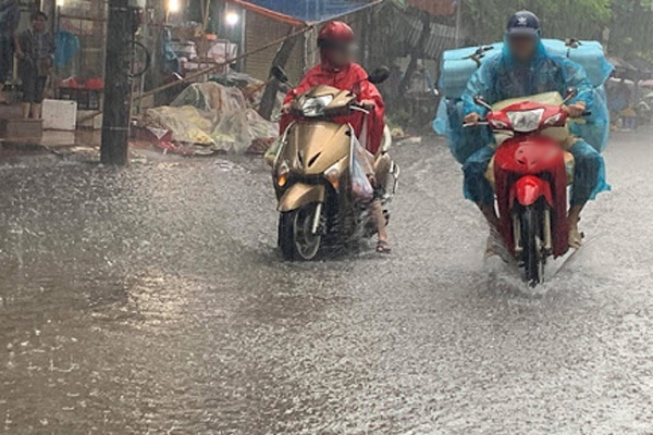  
Hình ảnh người dân di chuyển trong cơn mưa lớn. (Ảnh minh họa: VietNamNet)