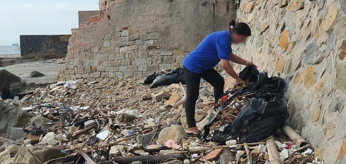  
Một trong những nữ nhân viên có hành vi gom rác vứt xuống biển. (Ảnh: VTC).