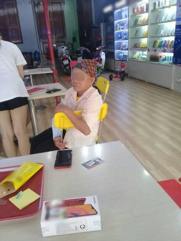  
Hình ảnh người mẹ ngồi chờ lấy điện thoại được nam thanh niên đăng tải trên mạng xã hội. (Ảnh: S.V.Q)