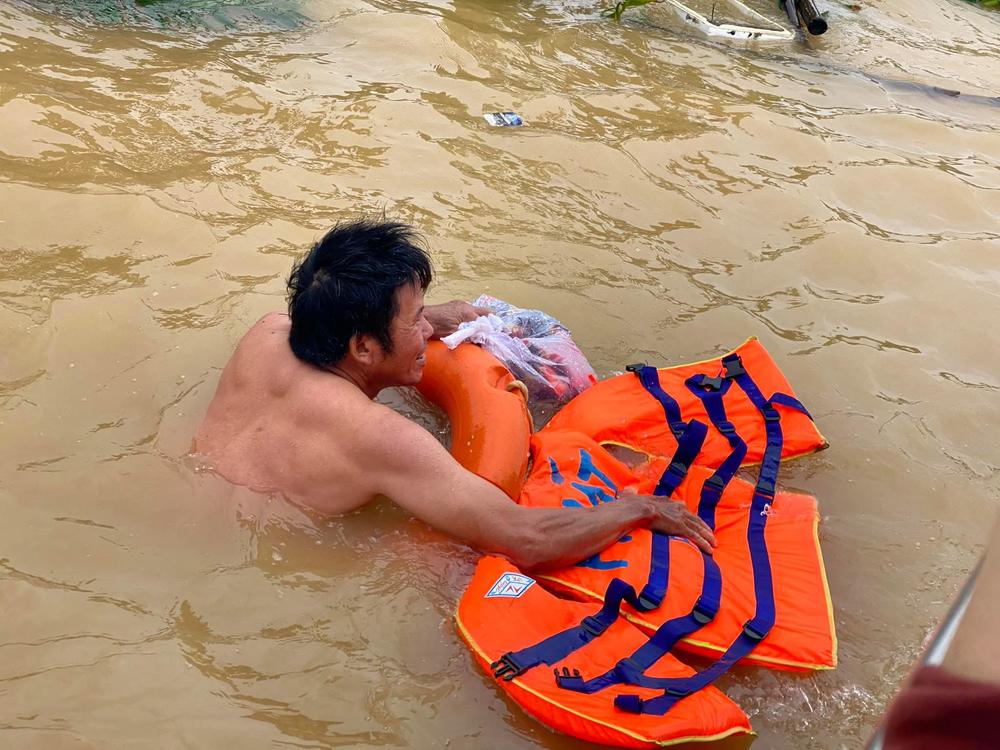  
Người dân mừng rỡ bơi ra để nhận đồ cứu trợ từ mem Việt Nam Ơi (Ảnh: Toán Nguyễn)