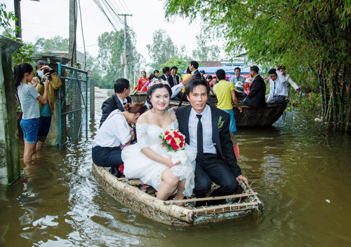  
Mặc nước dâng cao, cô dâu, chú rể vẫn vui vẻ "về chung một nhà" bằng thuyền. (Ảnh: Báo Quảng Nam)