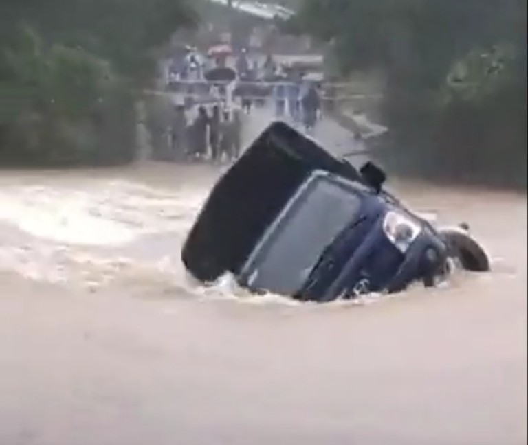  
Nước lũ chảy xiết và dâng cao và cuốn trôi chiếc xe. (Ảnh cắt từ clip)
