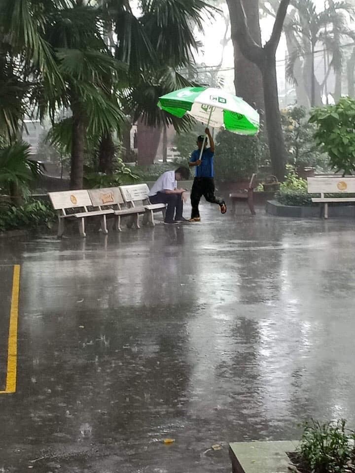  
Hình ảnh chú bảo vệ mang dù ra che mưa cho nam thanh niên từng được chia sẻ trên mạng xã hội. (Ảnh: FB MMP)