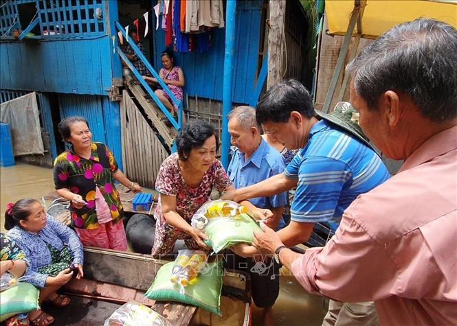 
Những người dân gốc Việt tại Campuchia bị ảnh hưởng của lũ lụt đã nhận quà từ Tổng lãnh sự quán Việt Nam tại tỉnh Preah Sihanouk . (Ảnh: TTXVN)