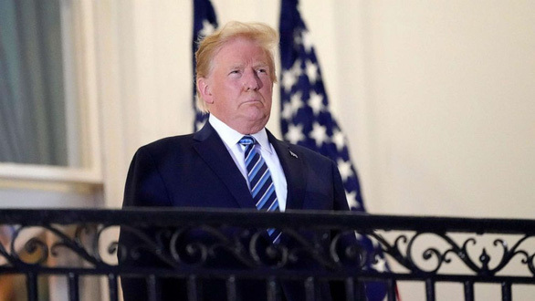 
Tổng thống Mỹ Donald Trump đứng trên ban công bên ngoài Phòng Xanh (Blue Room) khi từ viện trở lại Nhà Trắng ngày 5/10/2020. (Ảnh: AP)