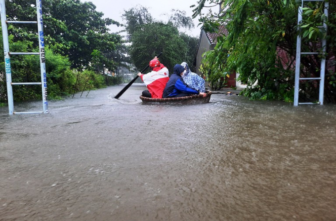 
Nước ngập cao khiến người dân phải dùng thúng để di chuyển. (Ảnh: VietNamNet).