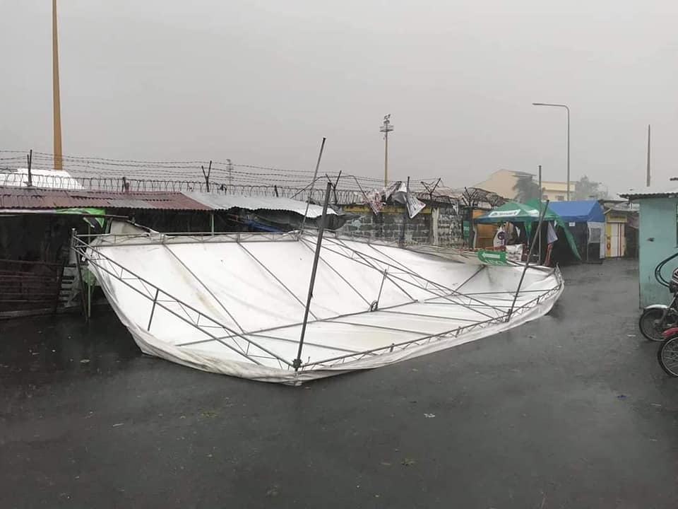  
Mái nhà bị tốc, biển quảng cáo bị đổ sập sau bão. (Ảnh: Reuters).