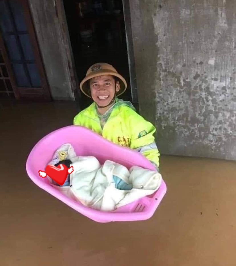  
Hình ảnh chiến sĩ nở nụ cười tươi khi giải cứu em bé khỏi căn nhà ngập lụt. (Ảnh: Đời sống)