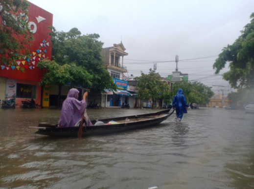  
Nước ngập tại 1 tuyến đường ở Huế, người dân dùng ghe để di chuyển. (Ảnh: Người Lao Động)