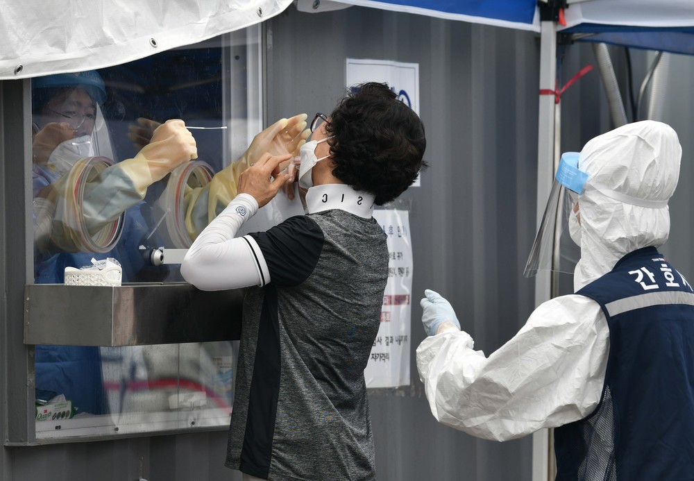  
Nhân viên y tế lấy mẫu xét nghiệm Covid-19 cho một người dân ở Hàn Quốc. (Ảnh: Straits Times)